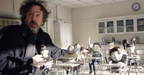 Tim Burton ao lado de uma cena do seu filme Frankenweenie. 