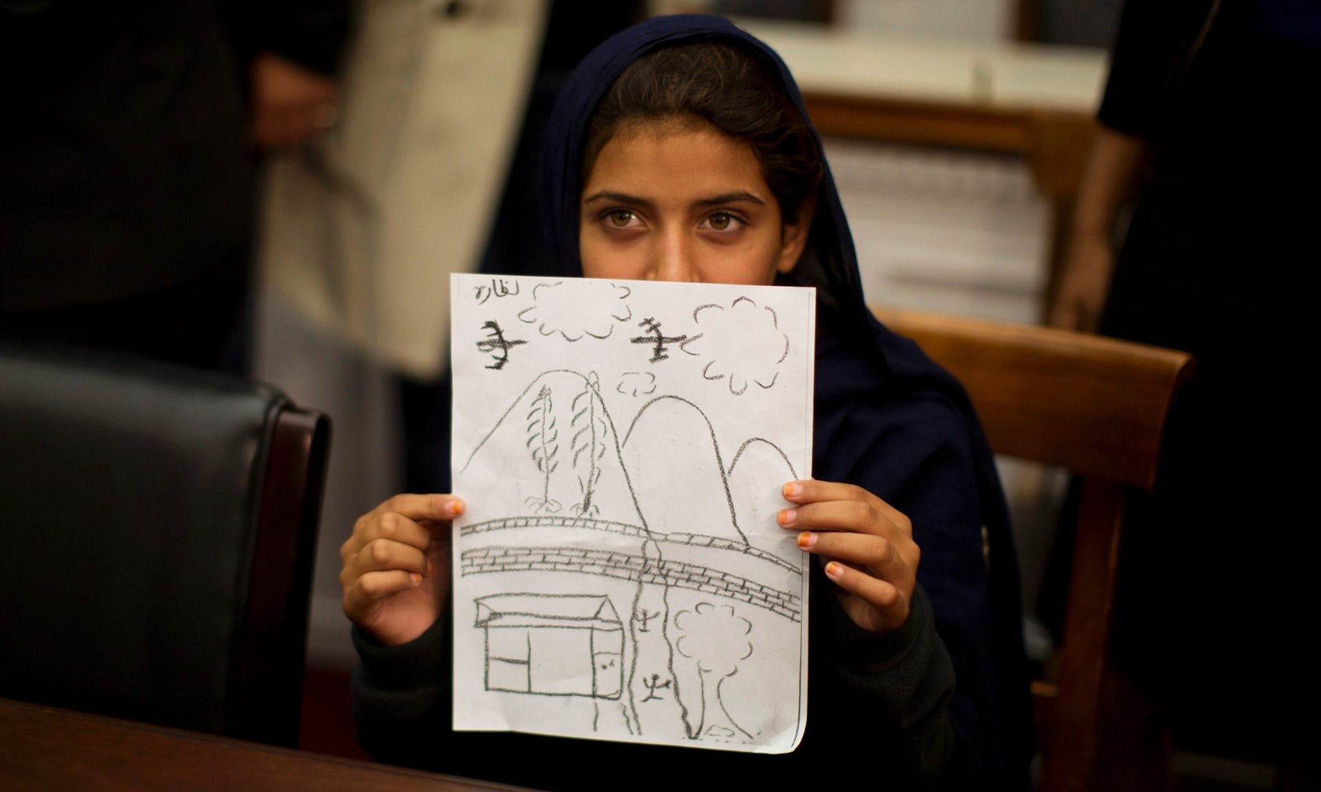 Nabila Rehman, 9, segura uma foto que ela desenhou descrevendo o ataque de drone em sua aldeia do Paquistão, que matou sua avó. Fotografia: Jason Reed / Reuters