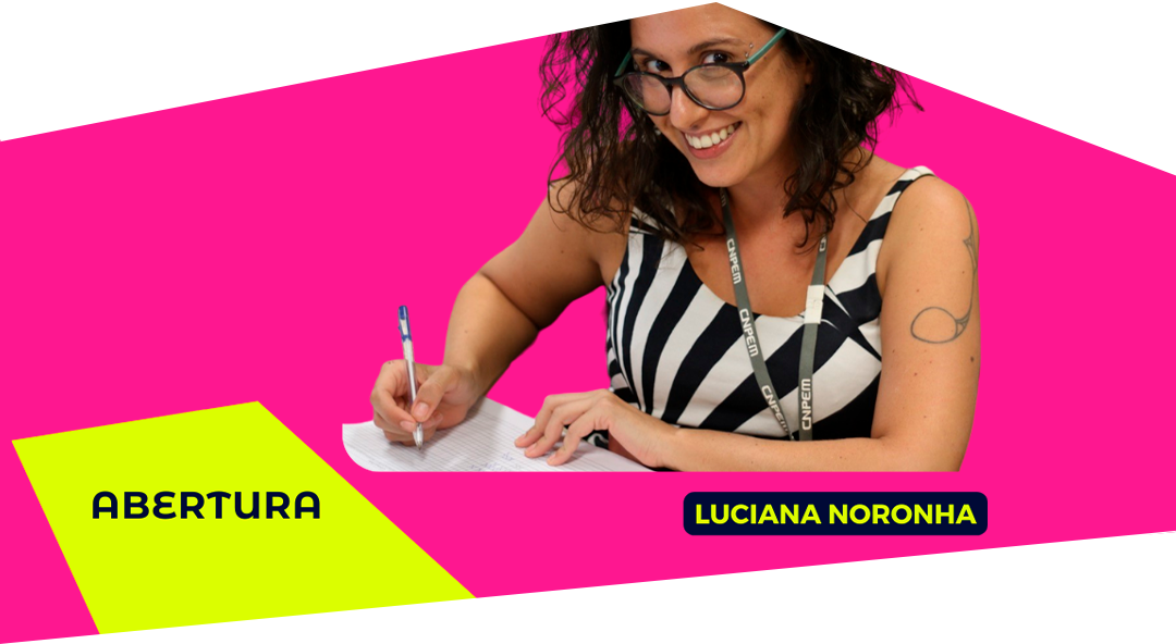 Imagem com o número da mesa redonda sua convidada: Luciana Noronha. Luciana é mulher, está sorrindo enquanto segura uma caneta sobre o papel, como se escrevesse.
