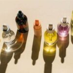 Imagem de vários vidros de perfume e cosméticos, sem identificação, vistos de cima.