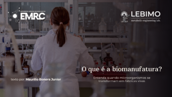 No canto superior direito há a logo do blog EMRC, no canto superior direito há a logo do LEBIMO, ao fundo se vê uma mulher branca, de costas, com cabelos castanhos amarrados em um rabo de cavalo trabalhando na bancada de um laboratório de biologia molecular. No canto inferior esquerdo está escrito "texto por Maurílio Bonora Junior" e no canto inferior direito há o título e a chamada do texto "O que é biomanufatura? Entenda quando microorganismos se transformam em fábricas vivas".