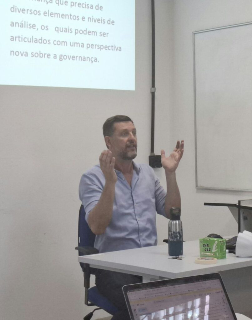 Mauricio Berger sentado enquanto fala no seminário “Coprodução da interface ciência-política: governança, autoridade e políticas da evidência”.