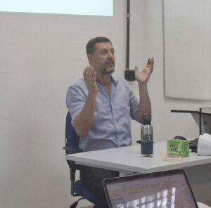 Mauricio Berger sentado enquanto fala no seminário “Coprodução da interface ciência-política: governança, autoridade e políticas da evidência”.