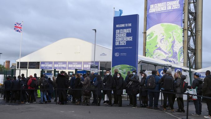 Delegates and participants line up at the main entrance to the COP26 Climate Change Conference 2021, Glasgow