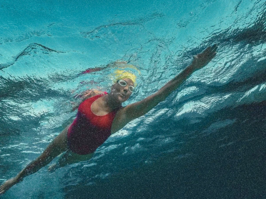 Representando Nyad, a foto, tirada de baixo da superfície da água, de uma nadadora.